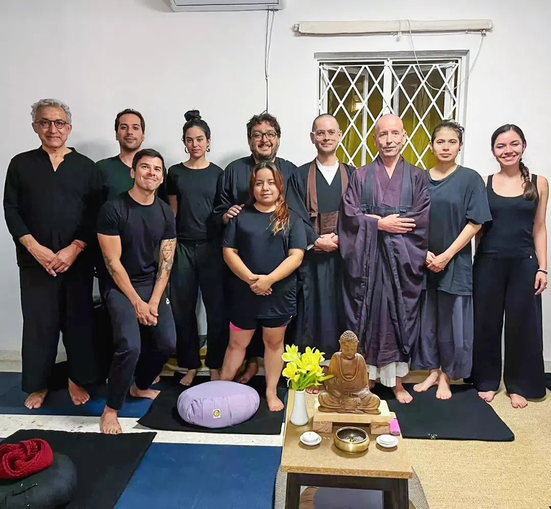 Dago Zamora junto a un grupo de practicantes en el Sanshin Dojo Monterrey, vestidos con uniformes tradicionales de práctica zen, posando en la entrada del dojo.